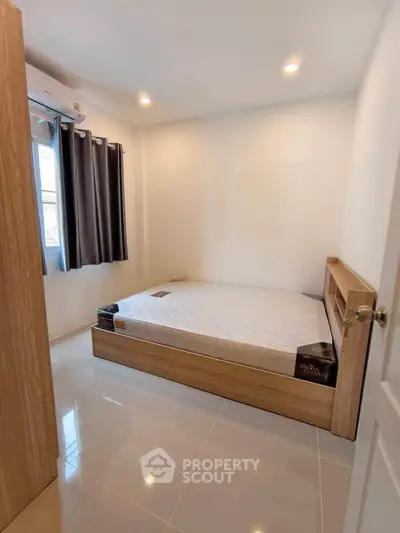 Cozy bedroom with natural light and modern furnishings in a stylish apartment.