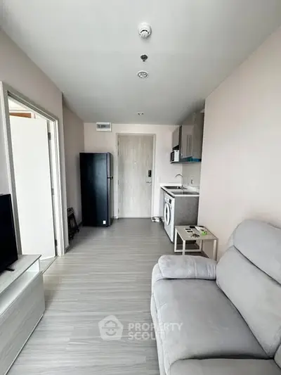 Modern compact apartment with sleek kitchen and cozy living area, ideal for urban living.