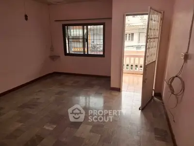 Spacious empty room with balcony access and tiled flooring