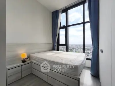 Modern bedroom with large windows offering stunning city views and elegant decor.