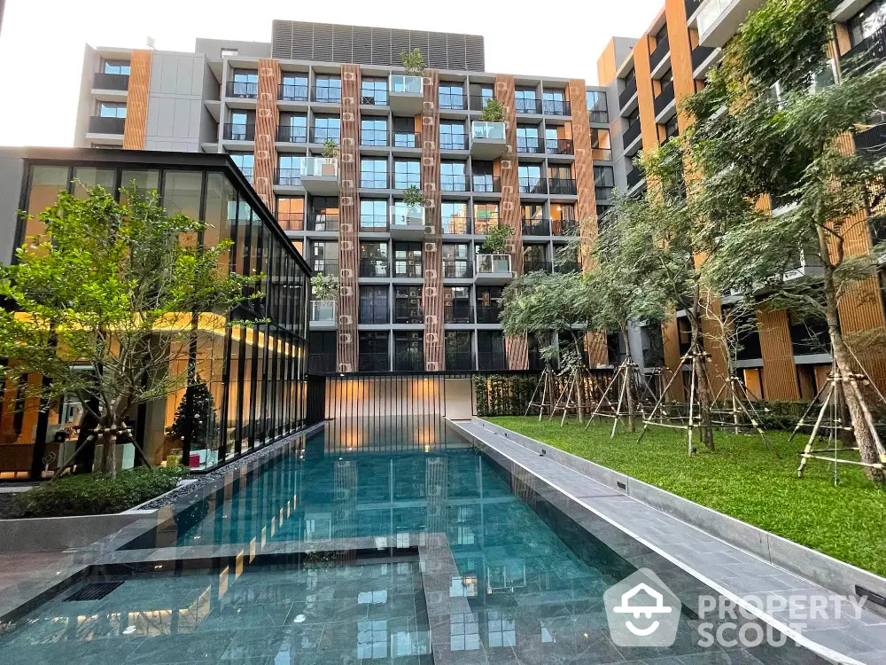 Modern apartment building with pool and landscaped garden