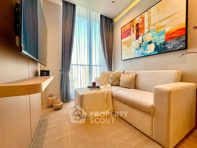 Modern living room with elegant decor and large window, featuring a cozy sofa and abstract art.