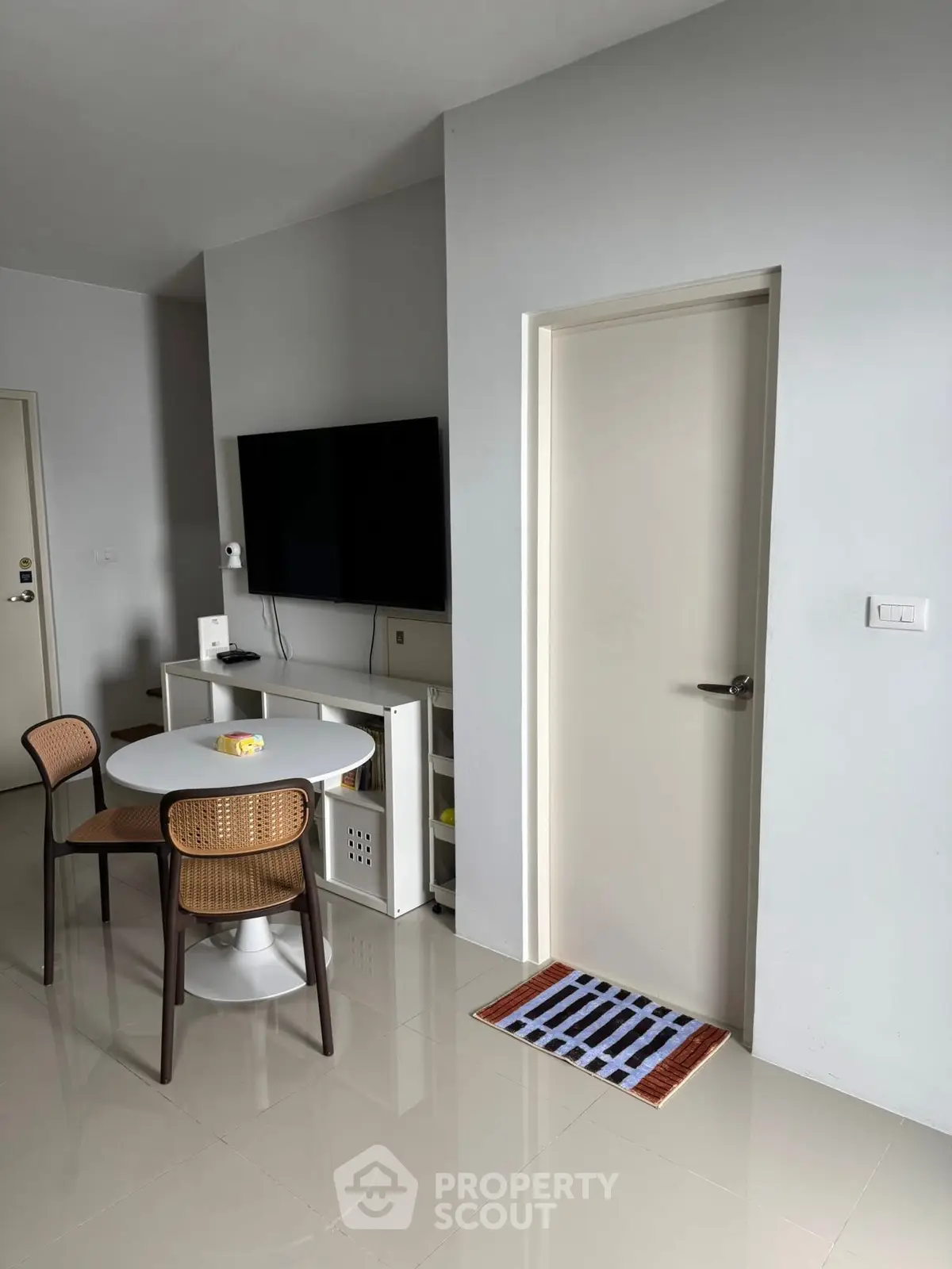 Modern living room with sleek TV setup and cozy dining area.