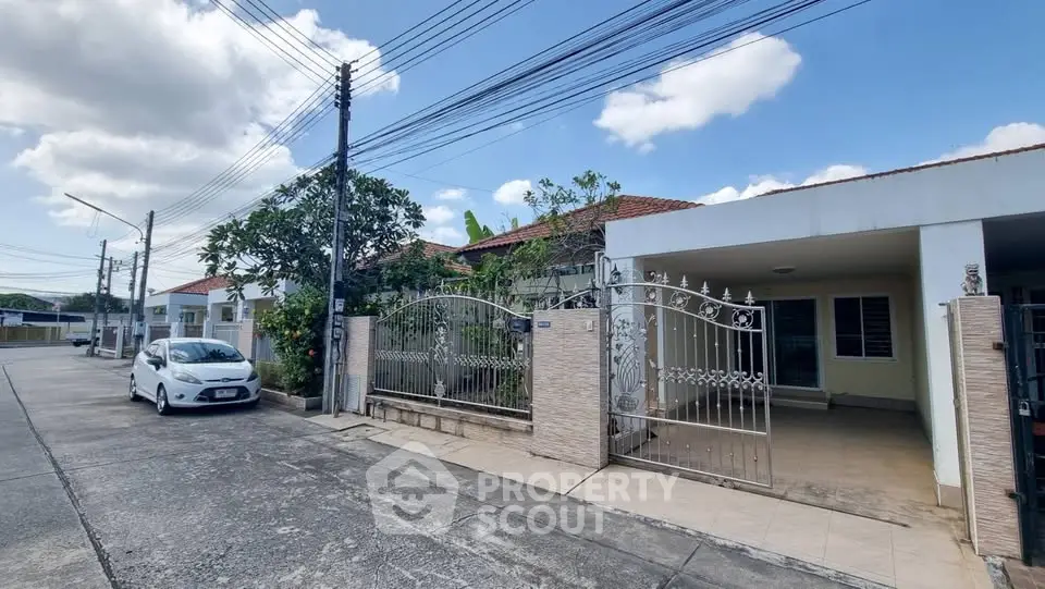 Charming suburban house with gated driveway and lush greenery, perfect for family living.