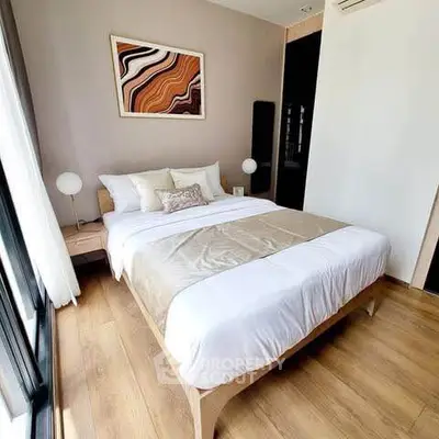 Modern bedroom with stylish decor and large window offering natural light.
