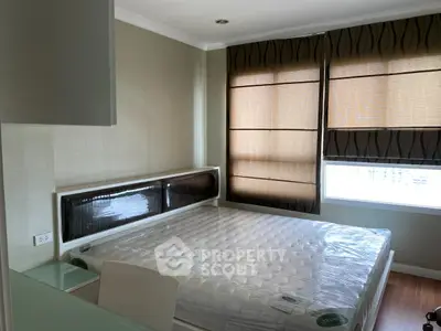 Modern bedroom with large windows and natural light, featuring a comfortable bed and stylish decor.