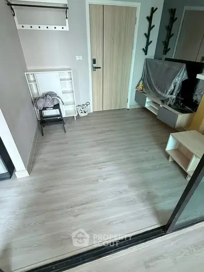 Modern apartment entrance with sleek wooden flooring and stylish storage solutions.