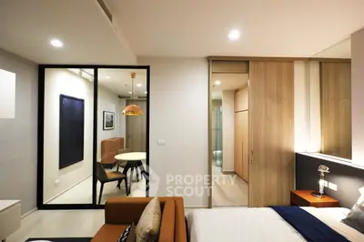 Modern bedroom with stylish decor and open layout leading to dining area.