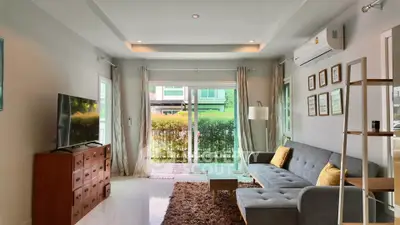 Modern living room with large windows, stylish furniture, and natural light.
