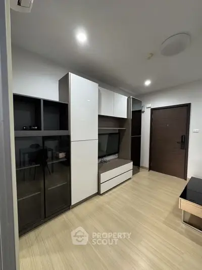 Modern living room with sleek storage cabinets and wooden flooring