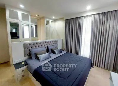 Modern bedroom with stylish decor and ample natural light from large window.