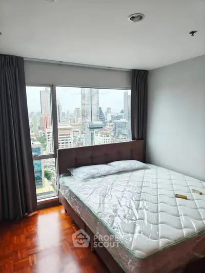 Modern bedroom with city view in high-rise apartment