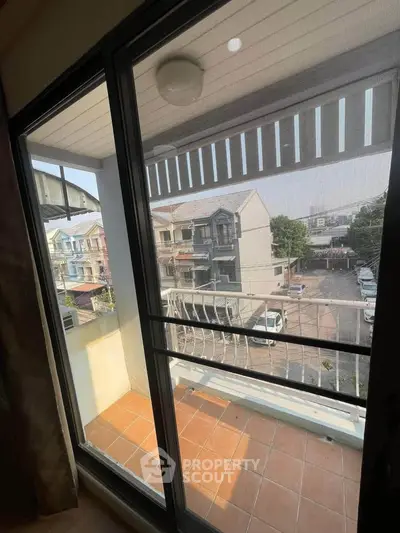 Charming balcony view overlooking residential neighborhood with tiled flooring and railing.
