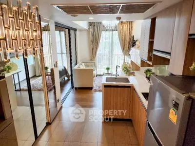 Modern open-layout kitchen and living room with stylish decor and natural light.