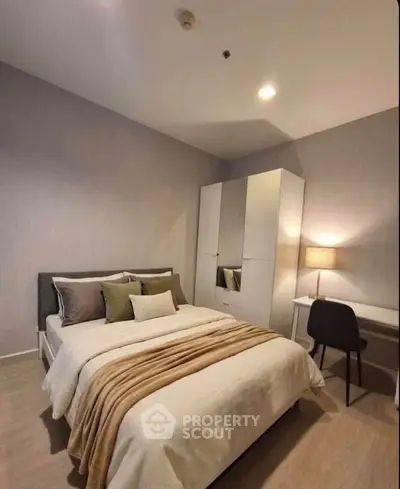 Cozy bedroom with modern decor, featuring a comfortable bed, stylish wardrobe, and a functional study desk.