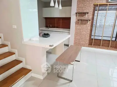 Modern kitchen with sleek design and open layout, featuring a stylish breakfast bar and contemporary lighting.
