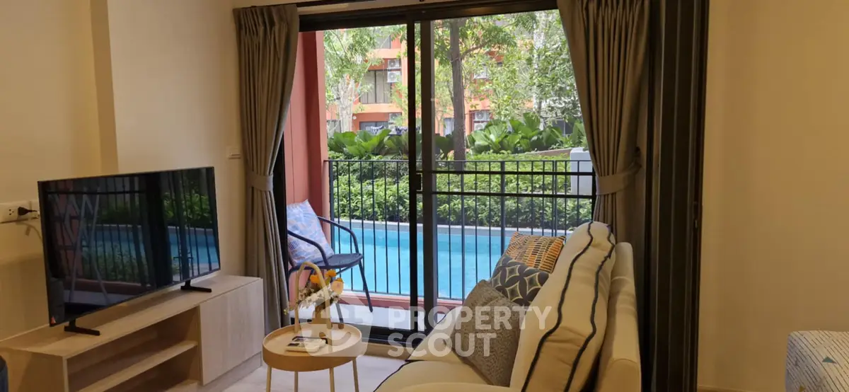 Charming living room with poolside view, cozy seating, and modern decor in a stylish apartment.