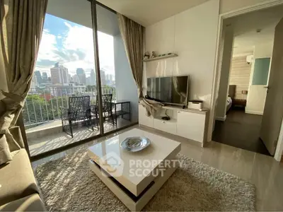 Modern living room with balcony and city view, featuring sleek furniture and natural light.