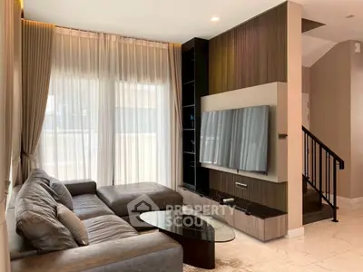 Luxurious living room with modern sectional sofa and large TV, perfect for relaxation.