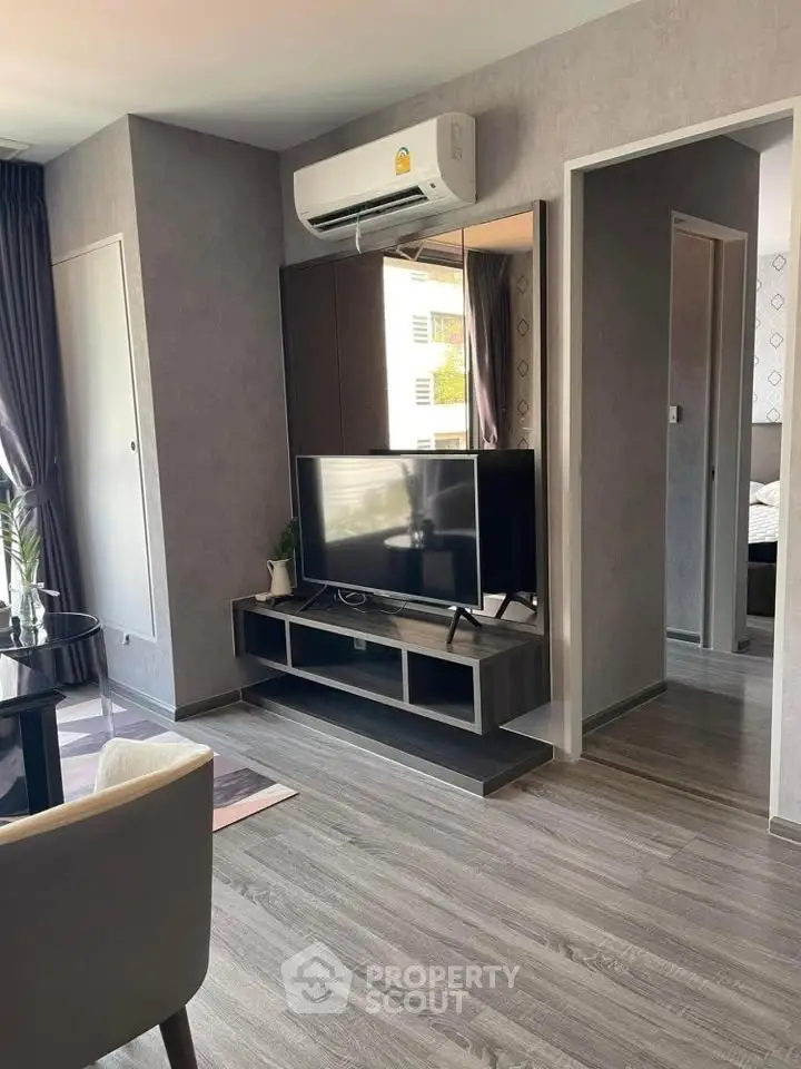 Modern living room with sleek TV setup and stylish decor in a contemporary apartment.