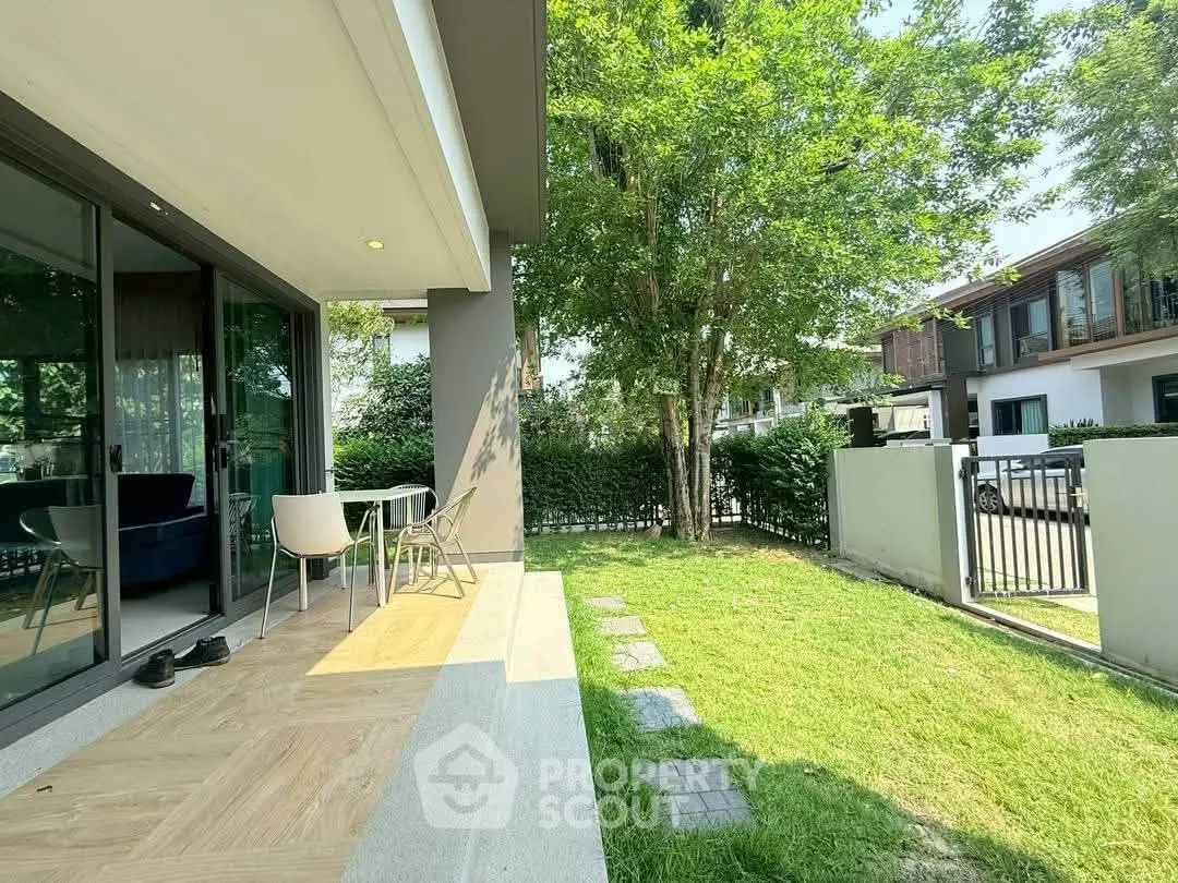 Charming garden view from modern patio with sliding glass doors and outdoor seating.