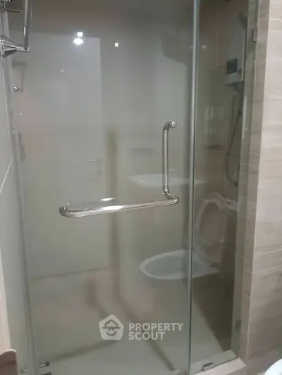 Modern bathroom with glass shower enclosure and sleek fixtures