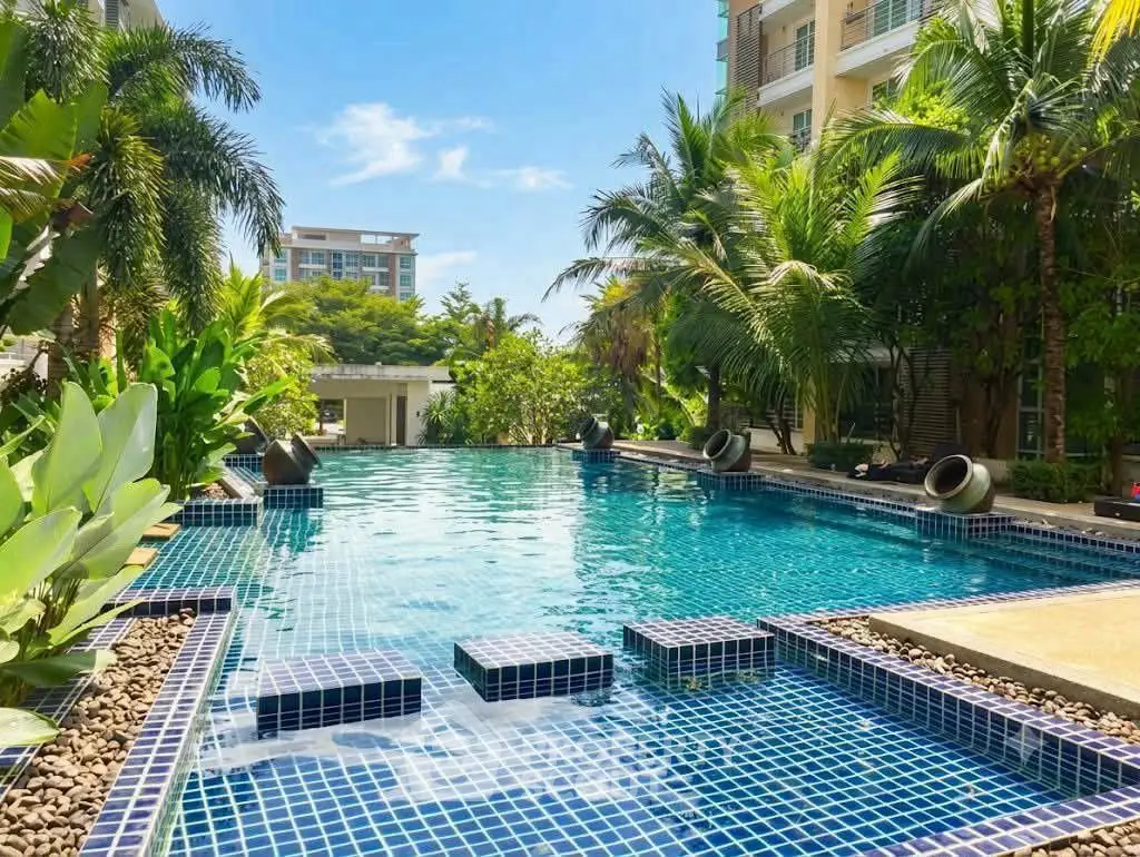Luxurious residential pool surrounded by lush greenery and modern architecture, perfect for relaxation and leisure.