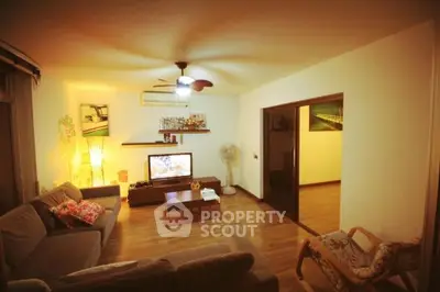 Cozy living room with modern decor and warm lighting, featuring a comfortable sofa and entertainment center.