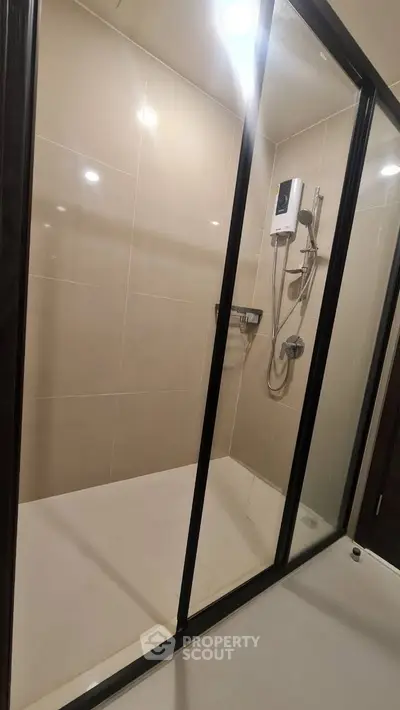 Modern bathroom with glass shower enclosure and sleek fixtures