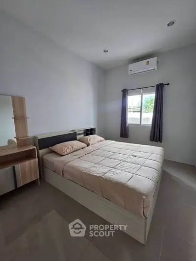 Spacious bedroom with modern furniture and natural light