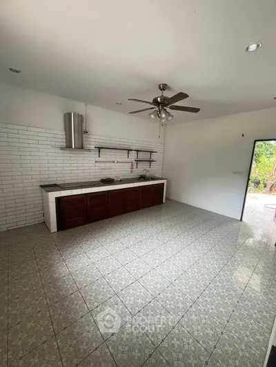 Spacious kitchen with tiled floor, ceiling fan, and modern cabinetry, offering a bright and airy atmosphere.