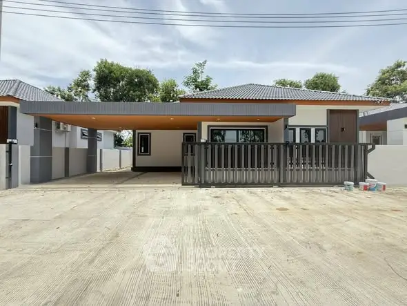 Modern single-story house with spacious driveway and sleek design.