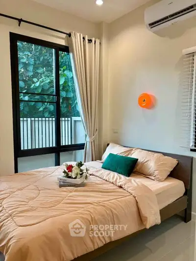 Cozy bedroom with large window and modern decor, perfect for relaxation and comfort.