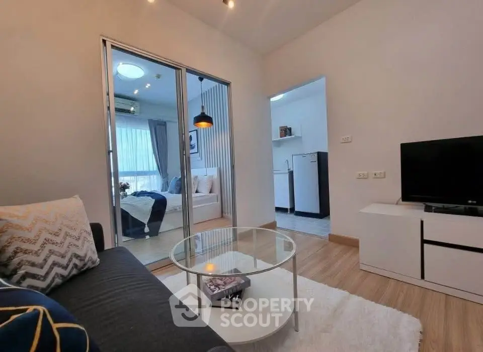 Modern living room with glass partition, cozy sofa, and stylish decor in a contemporary apartment.