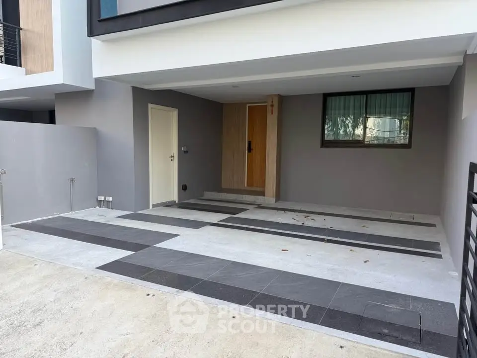 Modern residential entrance with sleek design and spacious driveway