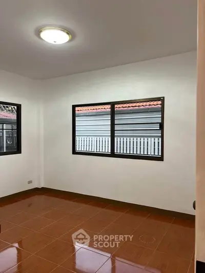 Spacious room with large windows and tiled flooring, perfect for customization.