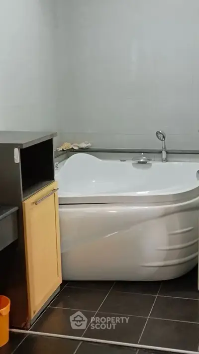 Modern bathroom with corner bathtub and sleek tile flooring