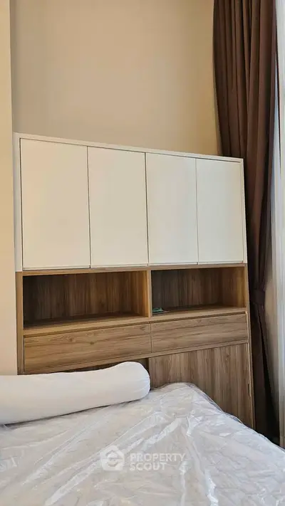 Modern bedroom with stylish wooden storage and elegant curtains