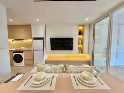 Modern open-plan living room with dining area, featuring sleek furniture and built-in appliances.