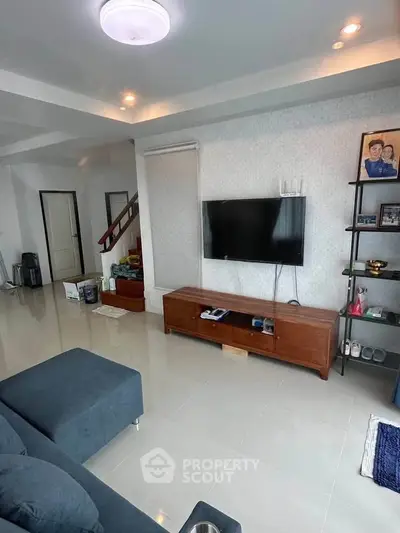 Modern living room with sleek TV setup and stylish furniture, perfect for relaxation and entertainment.