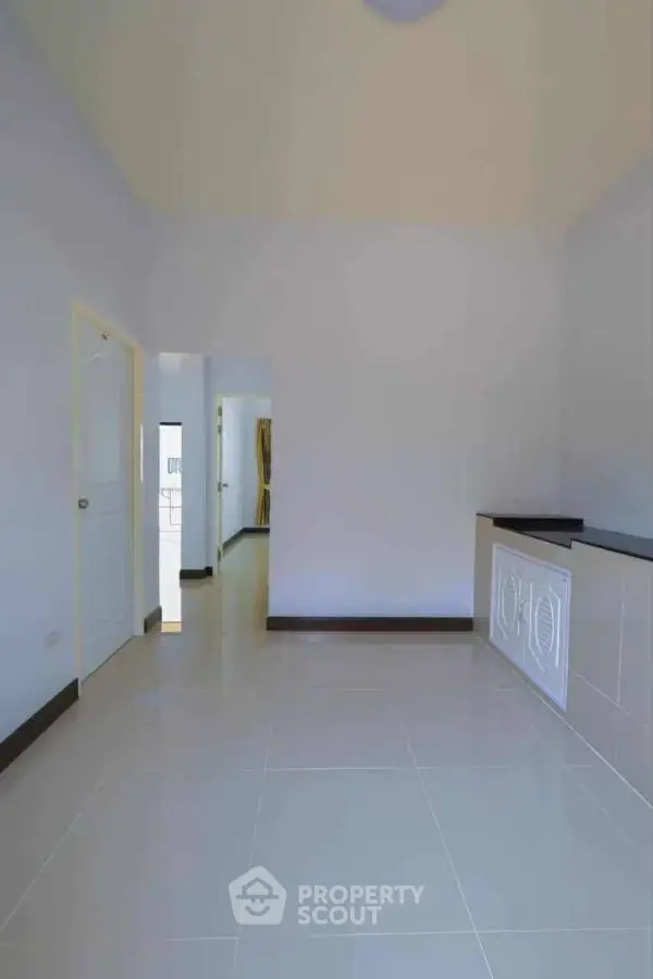 Spacious minimalist room with glossy tiled floors and elegant white walls