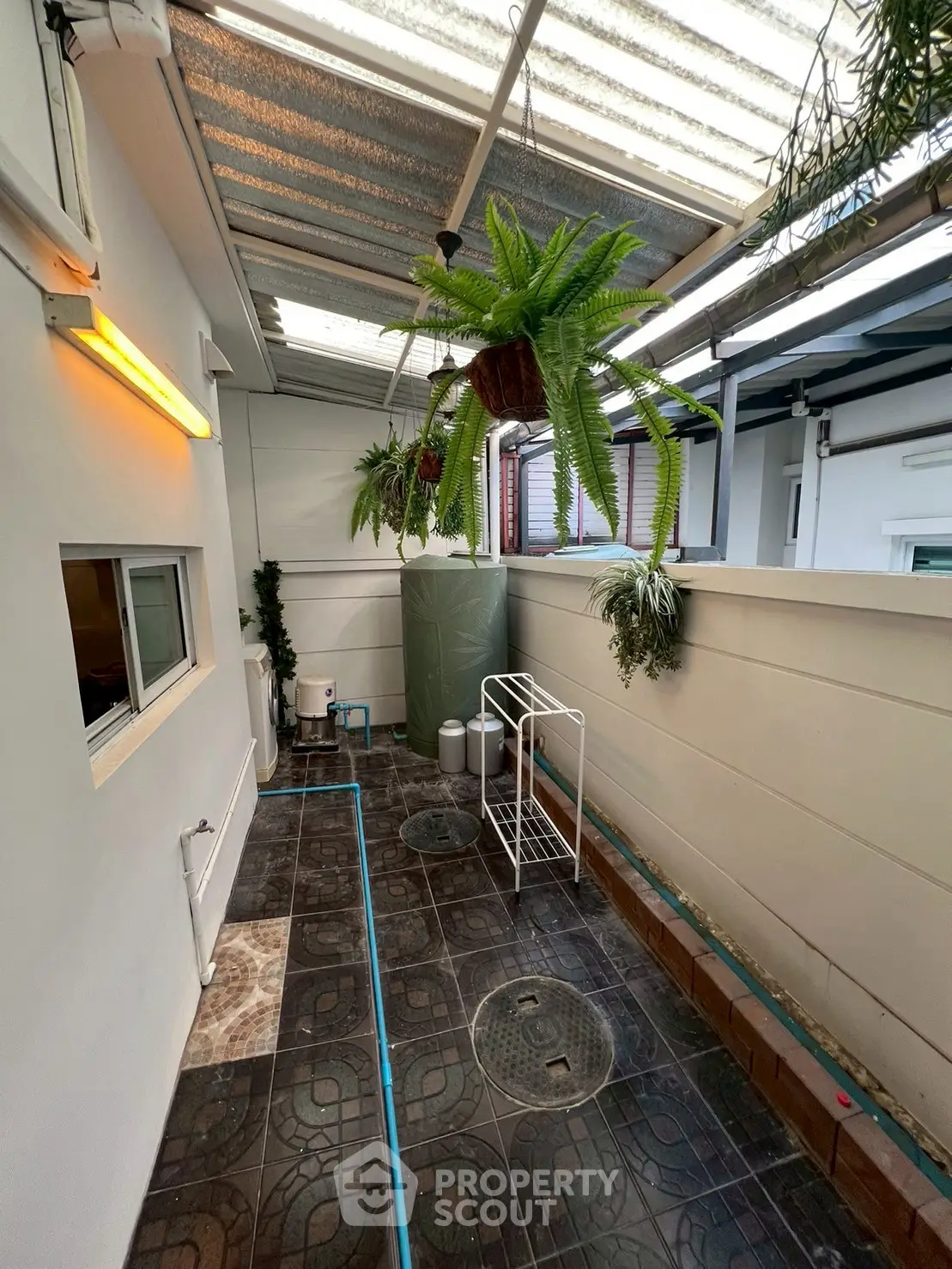 Charming covered outdoor space with hanging plants and modern flooring