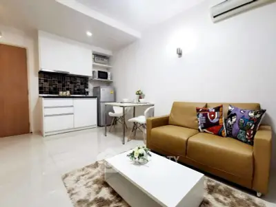 Modern living room with compact kitchen and stylish decor in a cozy apartment.