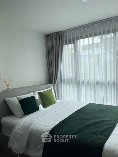 Cozy bedroom with modern decor and large window for natural light