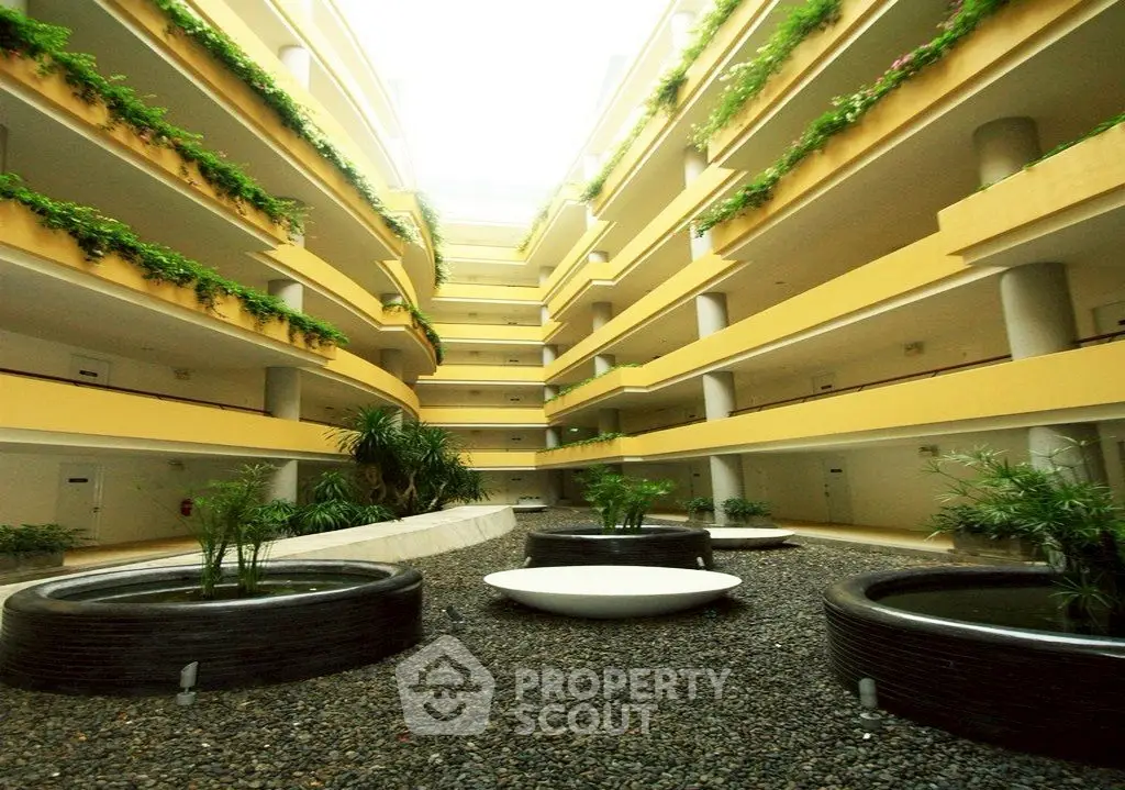 Stunning modern apartment building with lush greenery and open atrium design.