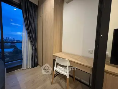 Modern study area with wooden desk and chair, featuring a large window with city view.