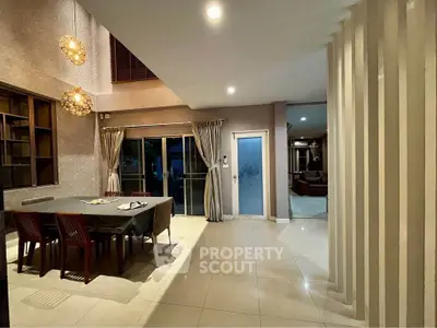 Spacious dining area with modern decor and elegant lighting in a luxurious home.