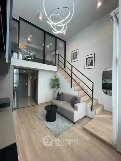 Modern loft-style living room with high ceilings and stylish staircase