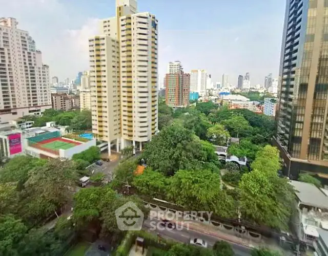 Stunning cityscape view with lush greenery and modern high-rise buildings.