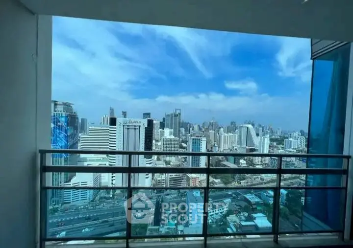 Stunning cityscape view from a modern high-rise balcony with clear blue skies.